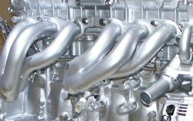 Polished stainless extractors on an engine